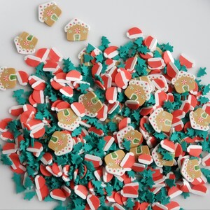 May include: Assortment of Christmas-themed sprinkles in red, white, and green. The sprinkles include gingerbread houses, Christmas trees, and Santa hats.