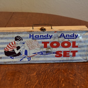 May include: A vintage blue and white metal toolbox with the words "Handy Andy Tool Set" and a picture of a boy building a doghouse. The toolbox is made by Blue Diamond Tools.