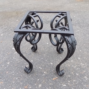 Può includere: Base per tavolo in metallo nero con volute e dettagli a foglia decorativi. La base è progettata per sostenere un piano da tavolo.