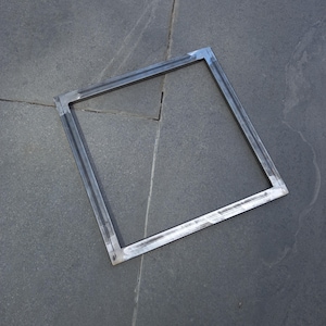 May include: A square metal frame with a welded construction. The frame is made of thick metal and has a silver finish.