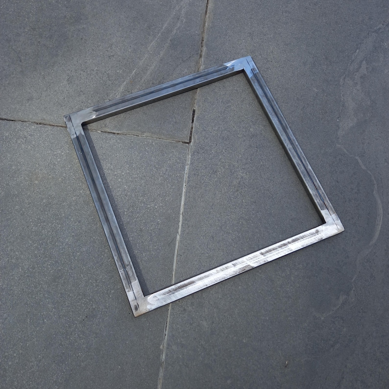 May include: A square metal frame with a welded construction. The frame is made of thick metal and has a silver finish.