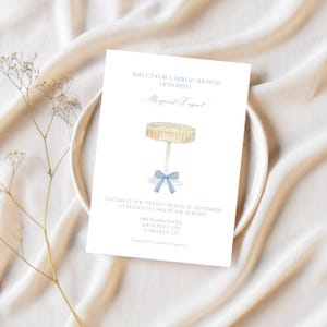 K&ouml;nnte beinhalten: Eine wei&szlig;e Einladung zu einer Brautparty mit blauem Text. Die Einladung zeigt eine Aquarell-Illustration eines Kuchentellers mit einem blauen Band. Der Text lautet: "Schlie&szlig;en Sie sich uns zu einer Brautparty zu Ehren von Margaret Deport an. Samstag, der 28. September um 11 Uhr morgens. Pinewood Social, 400 Jones Lane, Nashville, TN. Bitte melden Sie sich bis zum 1. August bei Caroline an."