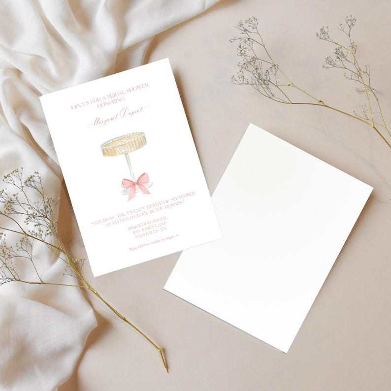K&ouml;nnte beinhalten: Eine rosafarbene und wei&szlig;e Einladung zu einer Bridal Shower mit einer Aquarell-Illustration eines Kuchengestells mit einer rosafarbenen Schleife. Die Einladung lautet "Join us for a Bridal Shower Honoring Margaret Dupont" und enth&auml;lt Datum, Uhrzeit und Ort der Veranstaltung.