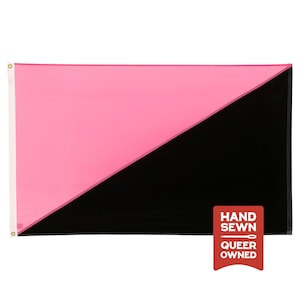 May include: A rectangular flag divided diagonally into a pink upper triangle and a black lower triangle. A white vertical strip with two brass grommets is on the left side. A red rectangular tag reads HAND SEWN with a needle icon and QUEER OWNED.
