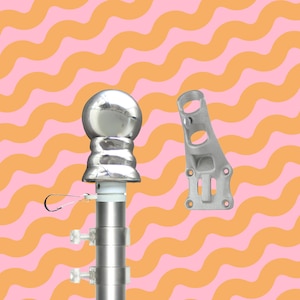 May include: A silver flagpole with a ball finial and mounting bracket. The pole is made of multiple sections and has adjustable clamps. The bracket has multiple holes for mounting. The background is a wavy pattern of pink and orange.