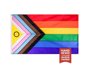 May include: A rectangular intersex-inclusive pride flag featuring horizontal stripes of red, orange, yellow, green, blue, and violet, with a chevron on the left containing black, brown, light blue, pink, white, and a yellow triangle with a purple circle.