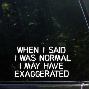 May include: A black car window with a white vinyl sticker that reads "When I said I was normal I may have exaggerated."