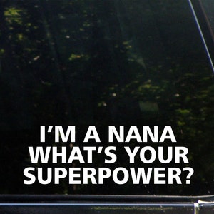 May include: White vinyl decal with the text "I'm a Nana What's Your Superpower?" on a black background.