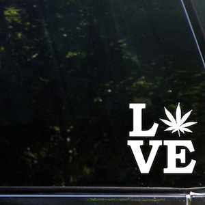 Op de afbeelding: Witte vinyl sticker met het woord "LOVE" waarbij een marihuanablad de "O" vervangt.
