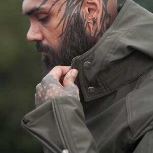 Close-up of men’s olive green GORE-TEX jacket showing collar design and zip detail.