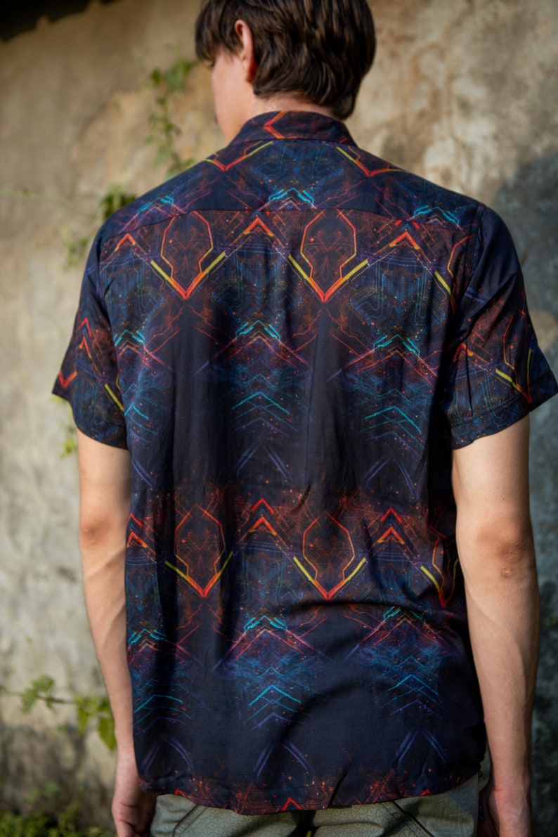 May include: A black short-sleeved button-down shirt with a geometric pattern in shades of red, orange, yellow, and blue.
