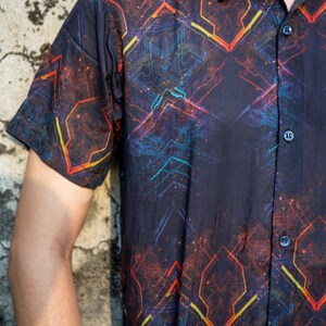 May include: A black short-sleeved button-down shirt with a geometric pattern in shades of red, orange, blue, and yellow.