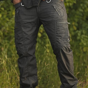 Op de afbeelding: Zwarte cargo broek met meerdere zakken en ritsdetails. De broek heeft een slanke pasvorm en is gemaakt van een duurzame, lichtgewicht stof.