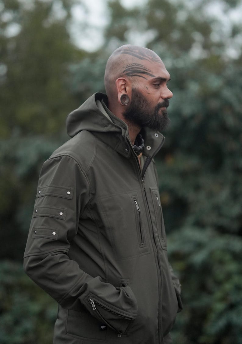 Men’s olive green GORE-TEX soft shell winter jacket with hood – side view outdoors.