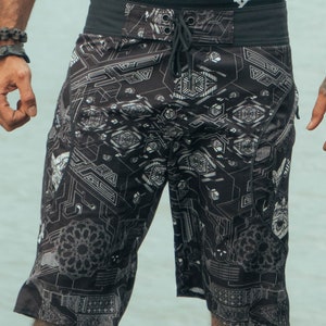Black swimming trunks with a white geometric pattern. The waistband is black with a drawstring.