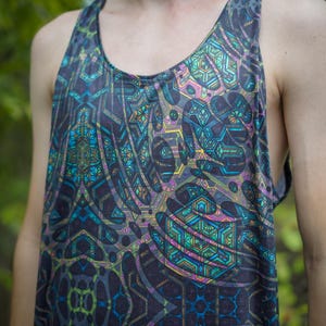 Puede incluir: Camiseta sin mangas con un patrón geométrico en tonos azules, verdes, morados y amarillos. El diseño presenta formas y líneas intrincadas, creando un efecto psicodélico. La camiseta sin mangas está hecha de un material suave y ligero.