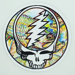 May include: A colorful sticker featuring a stylized skull with a lightning bolt design. The skull is surrounded by a colorful fish pattern.