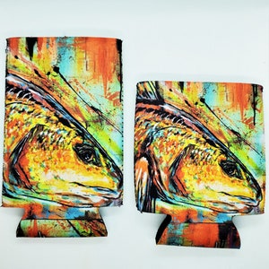 May include: Two colorful neoprene can coolers with a redfish design. The coolers feature a vibrant abstract background with splashes of orange, yellow, blue, and green.
