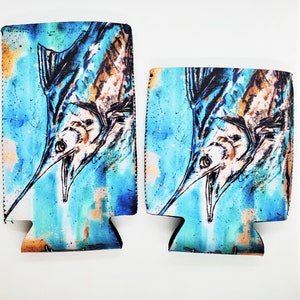 May include: Two blue and white neoprene can coolers with a watercolor illustration of a marlin fish. The marlin is facing the viewer with its mouth open and its dorsal fin extended. The background is a blue and white watercolor wash.
