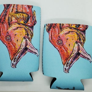 May include: Two blue and white neoprene can coolers with a colorful illustration of a fish with its mouth open. The fish is orange, yellow, and pink.