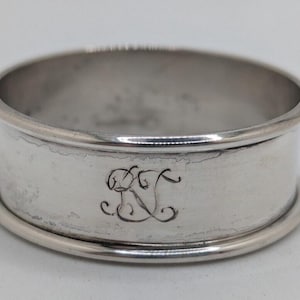 May include: A white ceramic mug with a black handle and the text "But first, coffee" in a black, handwritten-style font. The mug is on a white surface.