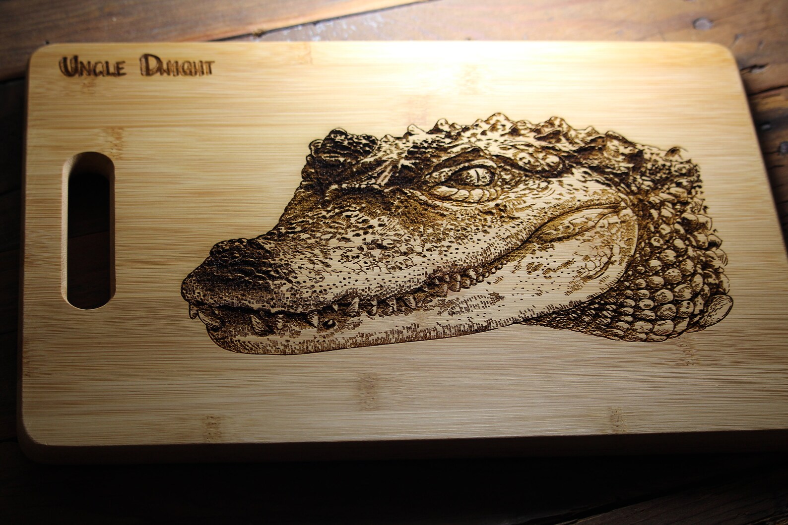 wooden cutting board with an alligator picture burnt into it.