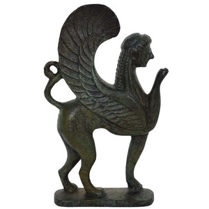 May include: A bronze sculpture of a winged griffin, a mythical creature with the head and wings of an eagle and the body of a lion. The sculpture is standing on a rectangular base.