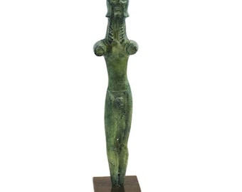 May include: A green bronze statue of a standing figure with a helmet on its head. The statue is on a black base.