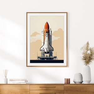 Pu&ograve; includere: Una stampa artistica incorniciata con un'illustrazione stilizzata di uno space shuttle su una piattaforma di lancio. Lo shuttle &egrave; bianco, arancione e nero, su uno sfondo di cielo beige con nuvole. La stampa &egrave; in una cornice di legno.