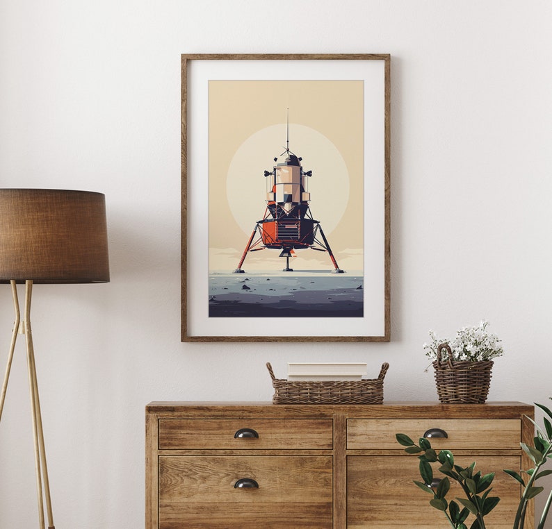 Pu&ograve; includere: Una stampa artistica incorniciata con un'illustrazione stilizzata del Modulo Lunare Apollo su una superficie lunare. L'opera d'arte ha un'estetica retr&ograve; con una tavolozza di colori tenui di arancione, beige e grigio. La stampa &egrave; esposta su una parete bianca sopra una cassettiera in legno.