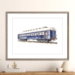 Op de afbeelding: Waterverfprint van een vintage blauwe passagierstreinwagon. De wagon heeft een wit dak en witte afwerking, tegen een witte achtergrond. Het kunstwerk is ingelijst in een grijze houten lijst.