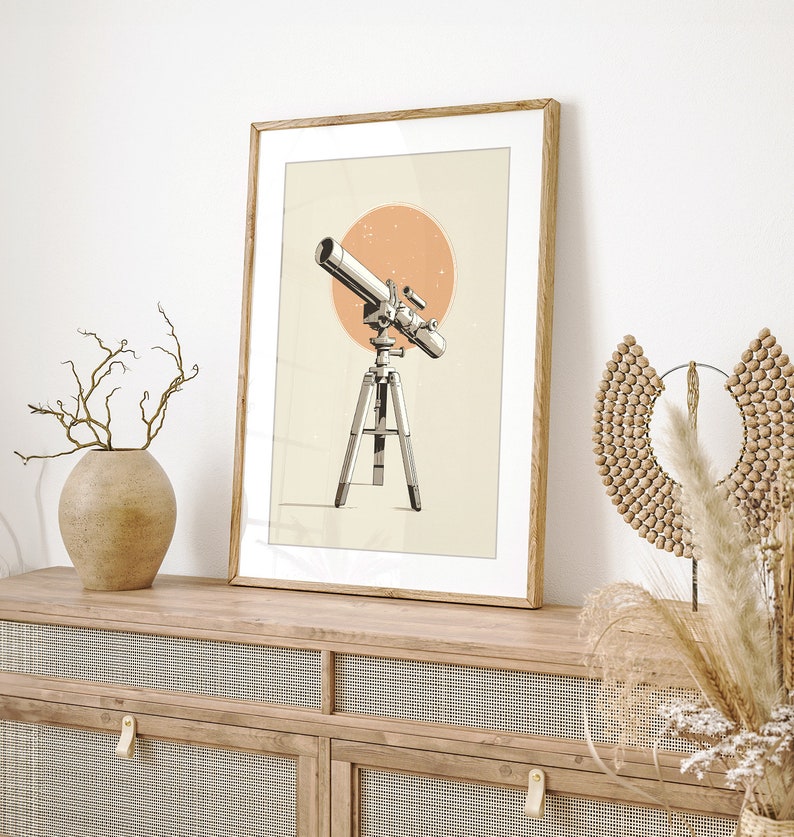 Pu&ograve; includere: Stampa artistica incorniciata con un'illustrazione dettagliata di un telescopio su un treppiede, su uno sfondo a forma di sole color pesca. L'opera d'arte &egrave; in una cornice di legno, che aggiunge un tocco di fascino vintage all'arredamento a tema celeste.