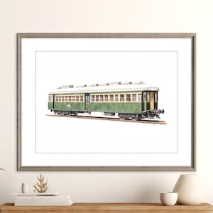 Op de afbeelding: Een ingelijste print van een vintage groene en witte passagierstreinwagon. De treinwagon is afgebeeld op een spoor, met gedetailleerde ramen en een klassiek ontwerp. Het kunstwerk staat tegen een witte achtergrond, ingelijst in een grijze houten lijst.