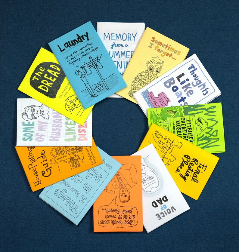 Puede incluir: Una colecci&oacute;n de diez fanzines coloridos con varios t&iacute;tulos e ilustraciones. Los fanzines est&aacute;n dispuestos en c&iacute;rculo sobre un fondo azul. Los t&iacute;tulos incluyen "The Dread", "Some of my Husband", "Like Dis", "Laundry", "Memory from a Summer", "Sometimes I Forget", "Thoughts Like Boats", "Petrified Creature Museum", "Final Resting Place", y "Voice of Dad".