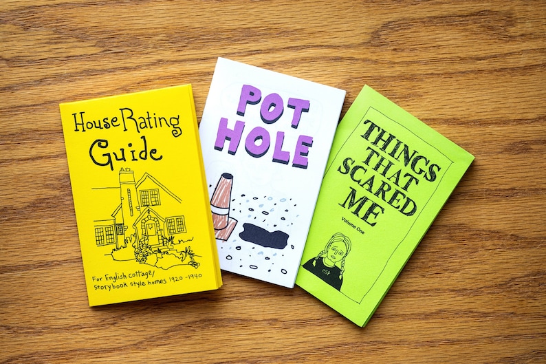 Puede incluir: Tres peque&ntilde;os libros de bolsillo coloridos con ilustraciones dibujadas a mano. El primer libro es amarillo con texto negro y un dibujo de una casa. El texto dice "House Rating Guide" y "For English cottage/Storybook style homes 1920-1990". El segundo libro es blanco con texto morado y un dibujo de un bache. El texto dice "POT HOLE". El tercer libro es verde con texto negro y un dibujo de una persona con los ojos cubiertos. El texto dice "THINGS THAT SCARED ME" y "Volume One".