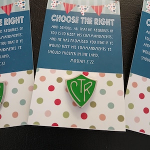 May include: A green shield-shaped pin with the letters CTR in white, attached to a card featuring a bunting design, polka dots, and the text: CHOOSE THE RIGHT AND BEHOLD, ALL THAT HE REQUIRES OF YOU IS TO KEEP HIS COMMANDMENTS; AND HE HAS PROMISED YOU THAT IF YE WOULD KEEP HIS COMMANDMENTS YE SHOULD PROSPER IN THE LAND. MOSIAH 2:22.