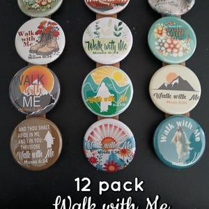 May include: A 12-pack of round pinback buttons with the text "Walk with Me" and "Moses 6:34" on each. The buttons feature various designs, including floral, mountain, and religious imagery. The buttons are attached to a brown strip.