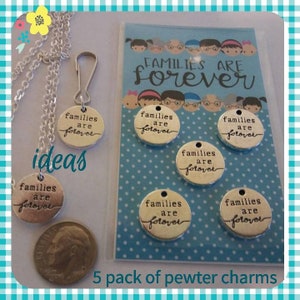 May include: Five silver charm pendants with the text "Families are forever" on a blue background with white polka dots. The charms are displayed on a card with the same text.