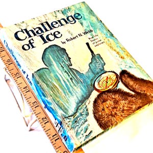 May include: Vintage book titled "Challenge of Ice" by Robert N. Webb. The cover features an illustration of a person in a parka, a compass, and a brown animal. The book's title is in large, bold letters.