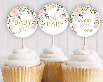 Puede incluir: Tres cupcakes con adornos de cupcakes de temática floral rosa y verde. Los adornos dicen "Baby Girl", "Oh Baby" y "Sweet Little One".