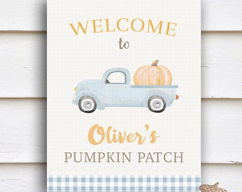 May include: A welcome sign for Oliver's Pumpkin Patch, featuring a blue truck with a pumpkin in the bed, a blue and white checked border, and the text "Welcome to Oliver's Pumpkin Patch".