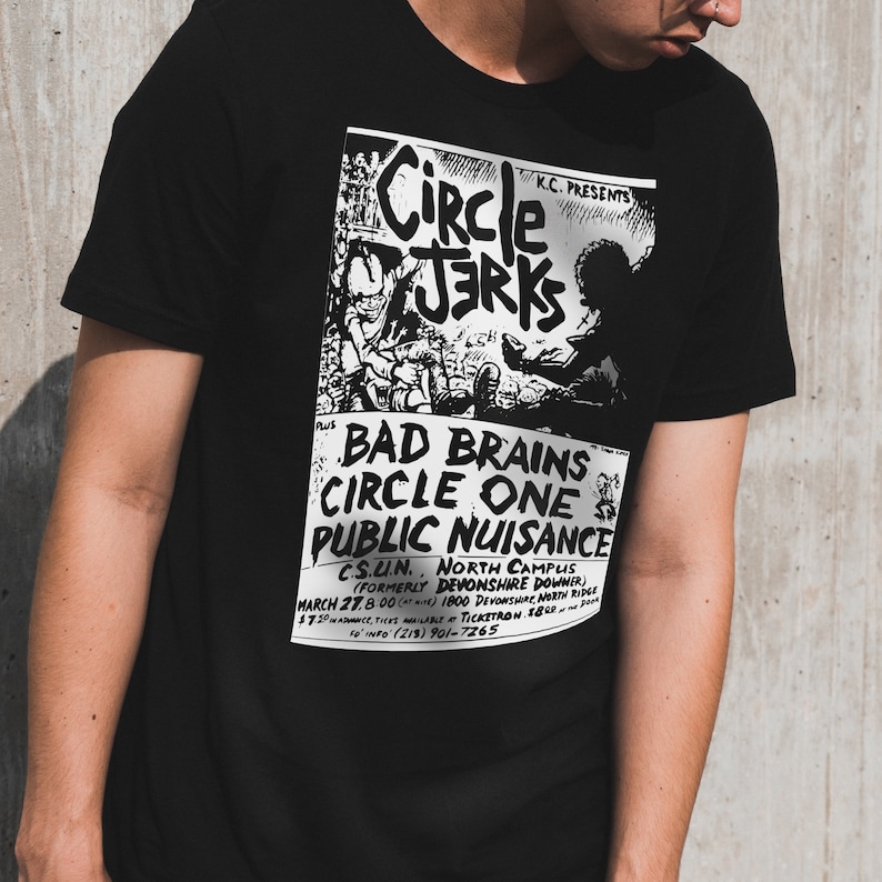 Pu&ograve; includere: Maglietta nera con una stampa bianca di un poster di un concerto che pubblicizza uno spettacolo con Bad Brains, Circle One e Circle Jerks. Il poster include la data, la posizione e le informazioni sui biglietti.