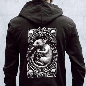 May include: Black hooded sweatshirt with a white graphic print of a rat inside an ornate frame with skulls and floral details.
