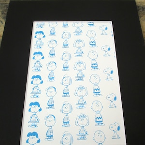 TWO Vintage Peanuts prints - featuring Charlie Brown, Snoopy and Gang. Both prints are pattern-like, with blue illustrations of characters.