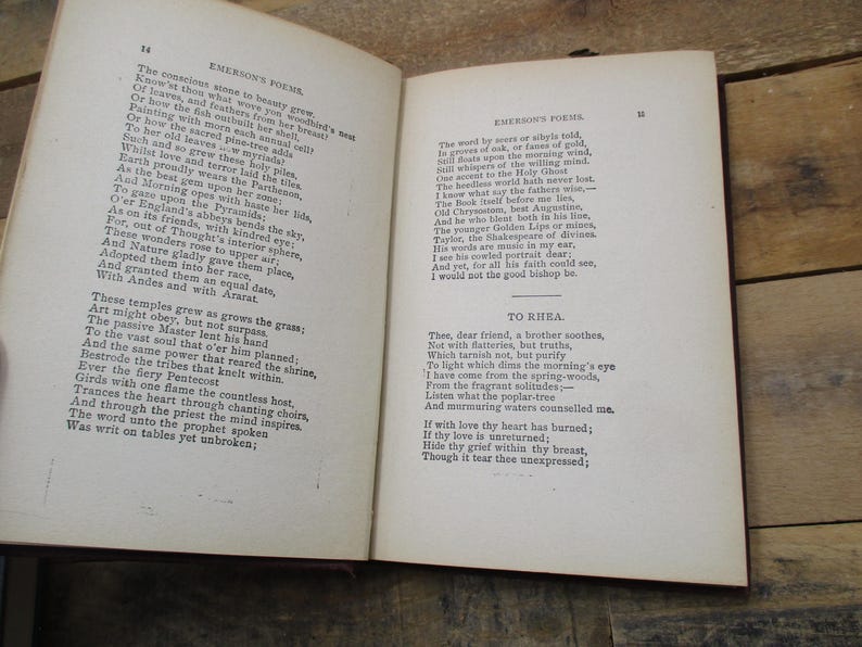 May include: An open book with yellowed pages, showing a poem by Ralph Waldo Emerson titled "To Kihla". The poem is printed in black ink on a white background. The book is bound in brown leather.