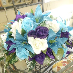 Sweetheart table centerpieces blue and purple roses and llilies