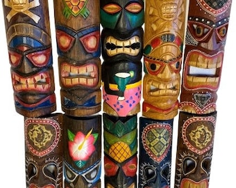 May include: A collection of carved wooden tiki masks in various colors and designs. Some masks feature skull, turtle, and pineapple motifs. The masks have open mouths and are painted with bright colors, showcasing a tropical theme.