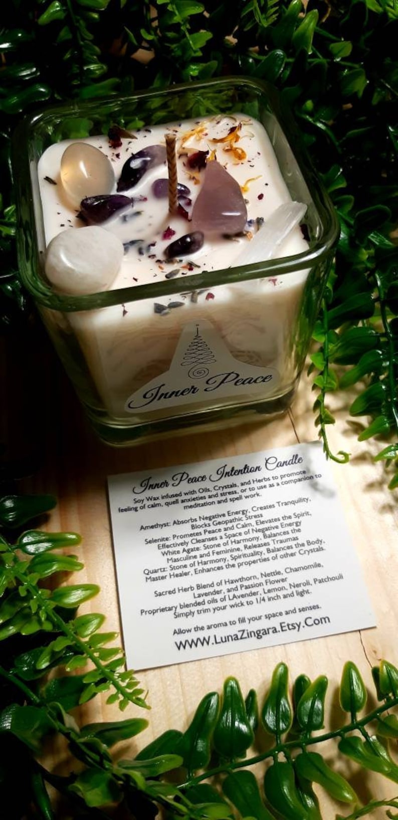 Pode incluir: Um frasco de vela quadrado de vidro com uma vela branca e v&aacute;rios cristais e ervas. A vela &eacute; etiquetada como "Inner Peace Intention Candle" e inclui uma descri&ccedil;&atilde;o dos cristais e ervas usados na vela. O texto inclui: Ametista, Selenita, &Aacute;gata branca, Quartzo, Espinho branco, Urtiga, Camomila, Lavanda, Flor da paix&atilde;o, Lim&atilde;o, Neroli, Patchouli. A vela est&aacute; sobre uma superf&iacute;cie de madeira com folhagem verde.
