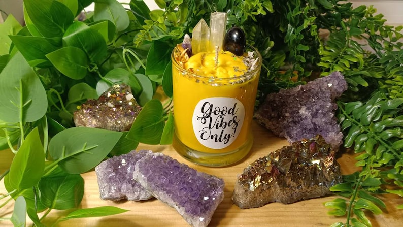 May include: A yellow candle with a white label that says "Good Vibes Only" surrounded by amethyst and citrine crystals.