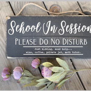 May include: Black wooden sign with white text that reads "School In Session PLEASE DO NO DISTURB Just kidding, send help... wine, coffee, private jet, math tutor."